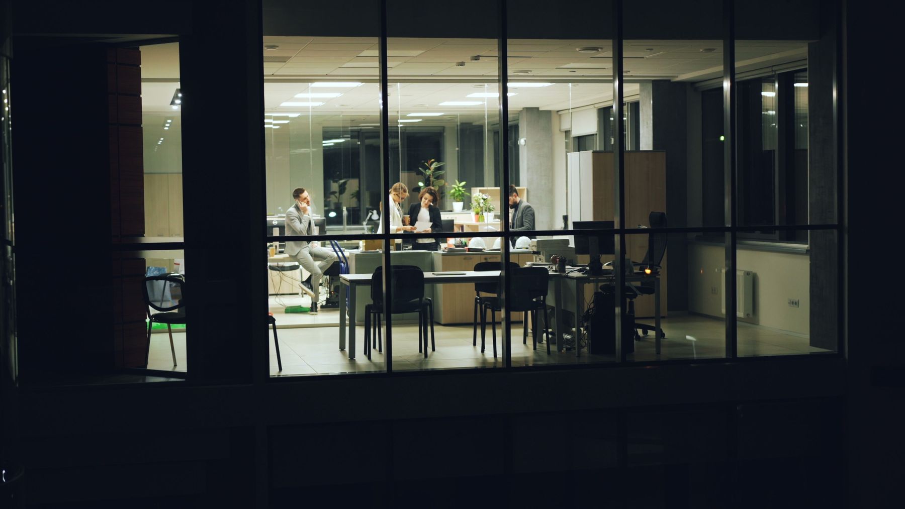 A modern professional team working together in an office at night